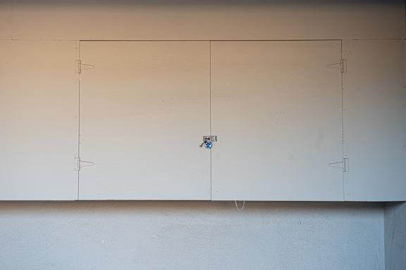 A white wall with a blue switch.