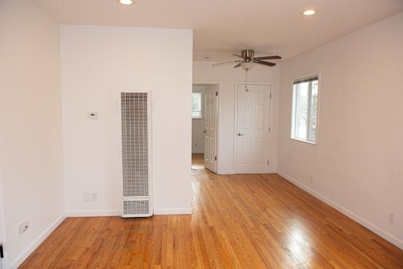 A room with a wood floor and a ceiling fan.