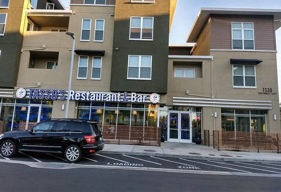 a black car parked in front of a restaurant bar