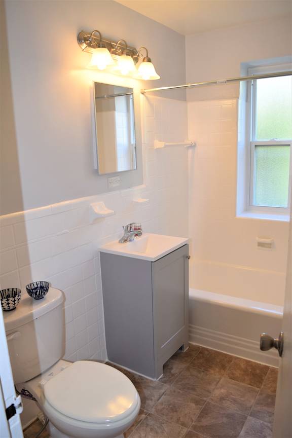 A white toilet sits next to a white sink in a bathroom.