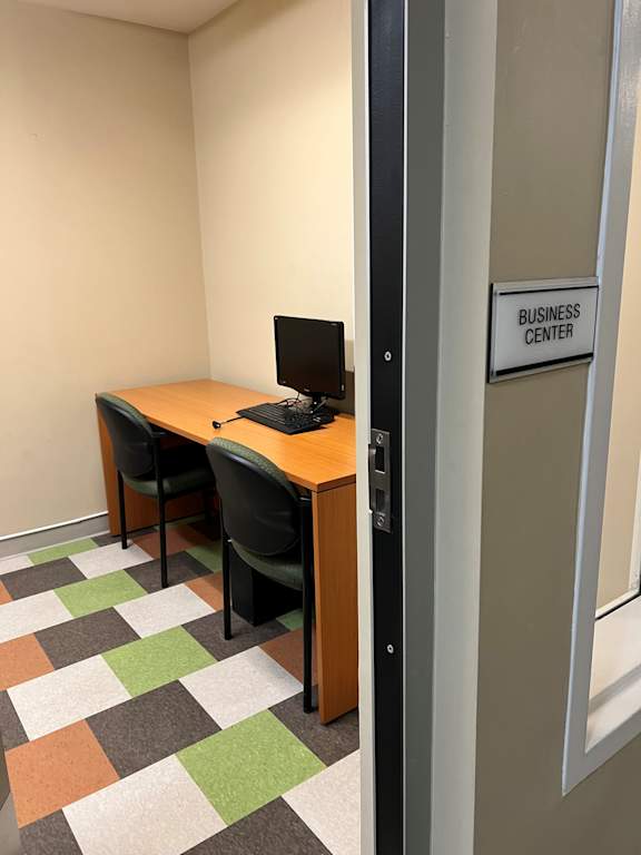 A small table with two chairs and a sign that says Business Center.