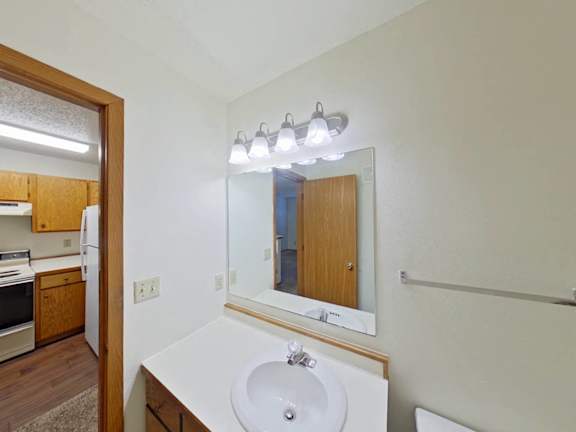 A bathroom with a sink, mirror, and light fixture.