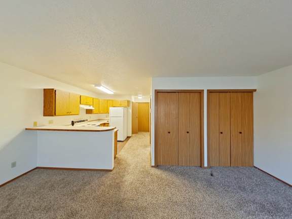 A room with a white counter and brown cupboards.