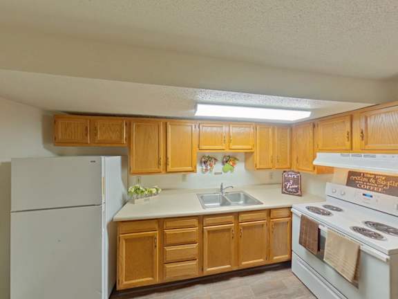 A kitchen with wooden cabinets and white appliances.
