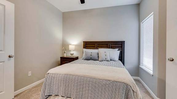a bedroom with a bed and a window. Circle Pines, MN Lexington Lofts