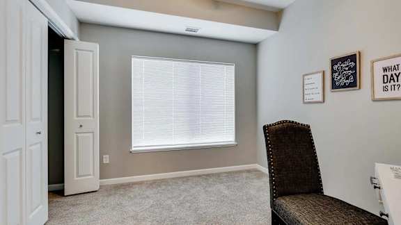 a living room with a chair and a window and a door.  Circle Pines, MN Lexington Lofts