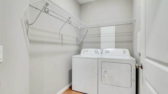 a washer and dryer in a laundry room with a rack on the wall Lexington Lofts
