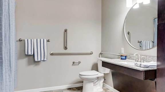 a bathroom with a toilet and a sink and a mirror. Circle Pines, MN Lexington Lofts