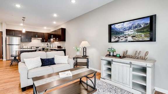 a living room and kitchen with a couch and a table. Circle Pines, MN Lexington Lofts