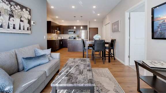 a living room and kitchen with a couch and a table. Circle Pines, MN Lexington Lofts