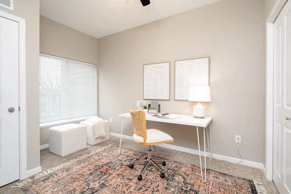 a home office with a desk and a window. Circle Pines, MN Lexington Lofts