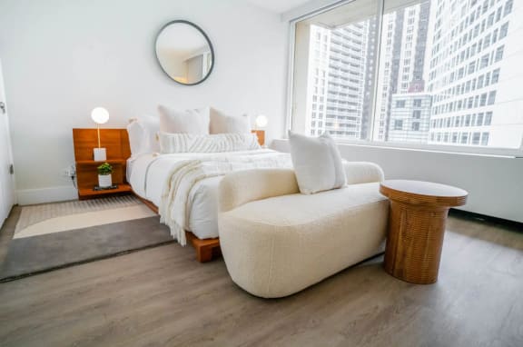 a bedroom with hardwood floors with a large bed and a large window