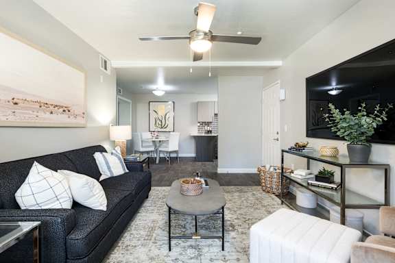 A modern living room with a kitchen area in the background.