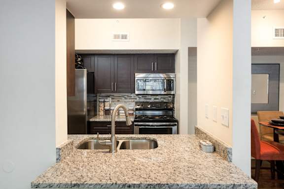 A kitchen with granite countertops and stainless steel appliances.