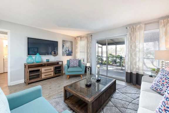 A living room with a television, a sofa, a chair, and a coffee table.