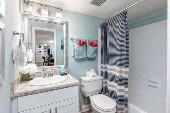 A bathroom with a sink, toilet, and shower.