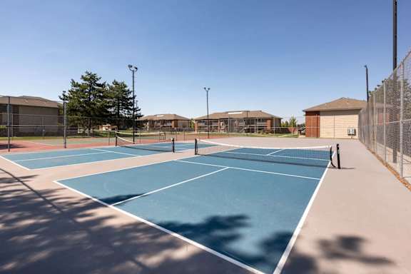 A tennis court with a blue surface and white lines.