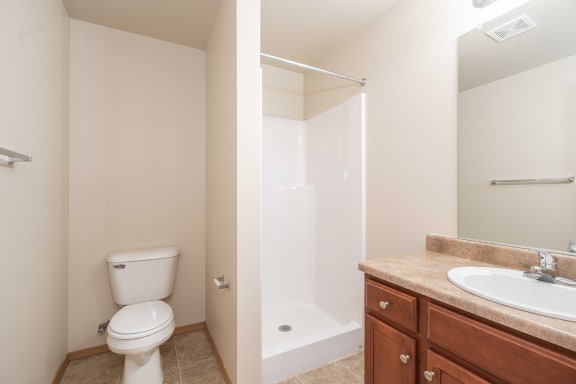 a bathroom with a toilet and a sink and a shower at Benson Village Townhomes Apartments, Sioux Falls