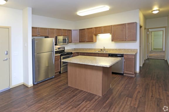 a kitchen with an island and stainless steel appliances  at Augusta Apartments, North Dakota