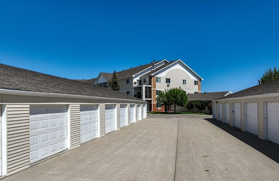 A row of white garage doors in front of a house.