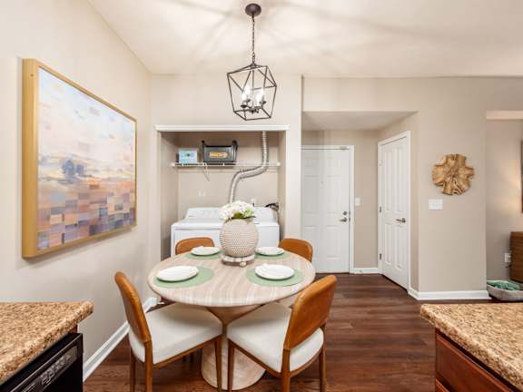 A dining room with a round table and chairs.