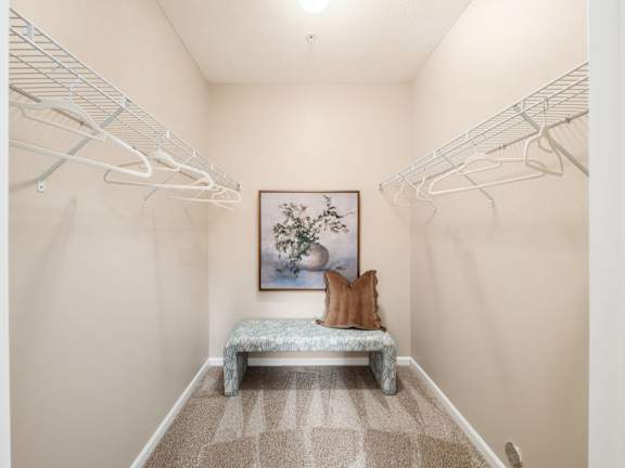A room with a bench and a painting of a rabbit.