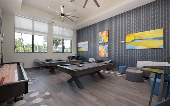 A room with a pool table and a billiard table.