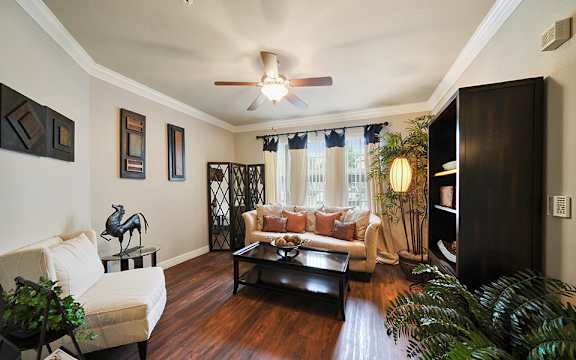 A living room with a white couch and a wooden floor.