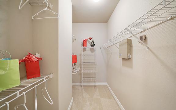 A white closet with a white shelf and a white hanger.