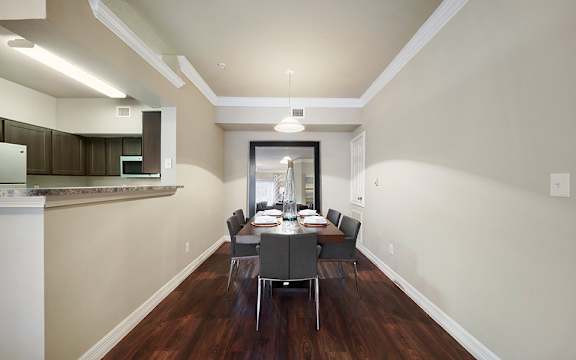 A dining room with a table set for six.