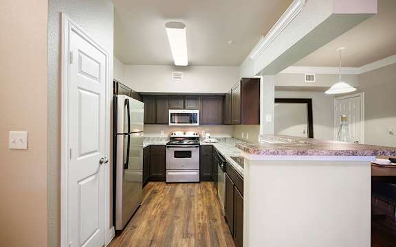 A kitchen with a white door and a white counter.