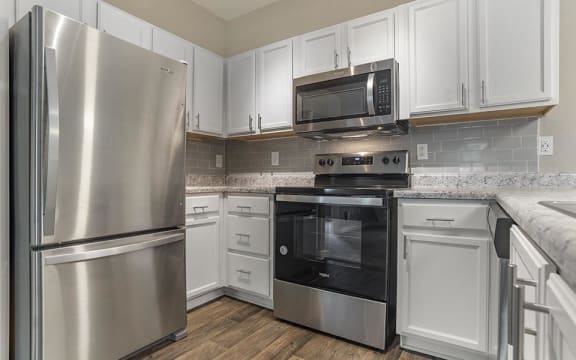 a kitchen with stainless steel appliances and white cabinets