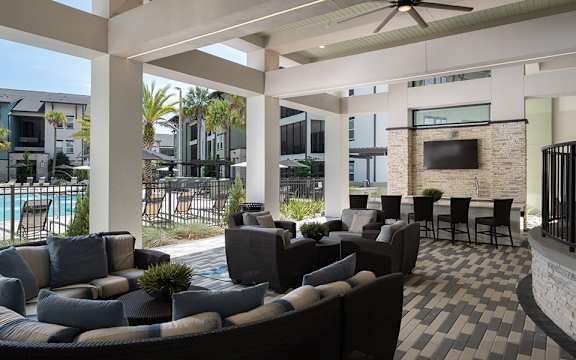 A patio with a black and white checkered floor and a stone wall.