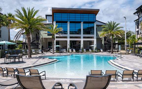 A large building with a pool in front of it.