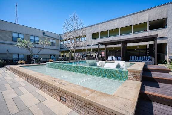 A small pool with a tiled edge sits in a courtyard.
