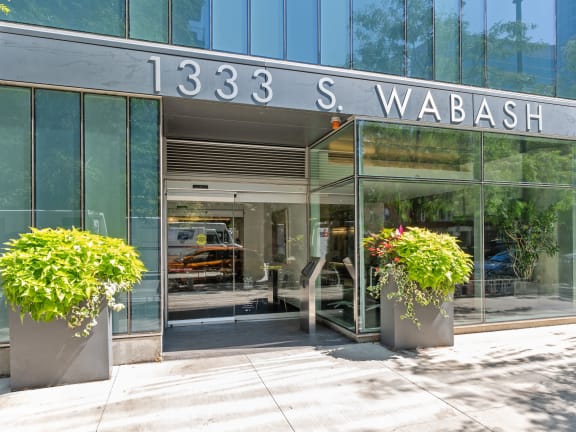 the front of a glass building with flowers in front of it at One 333, Chicago, IL, 60605