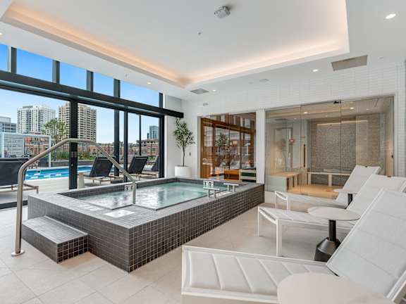A modern indoor swimming pool with a view of the city.