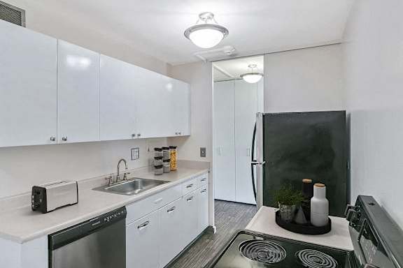A modern kitchen with white cabinets and a black stove top.