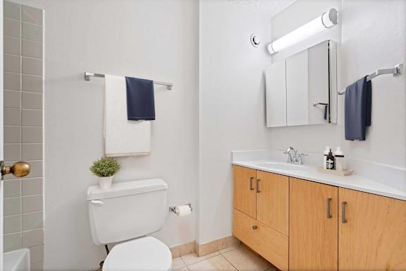 A white toilet sits next to a white sink in a bathroom.