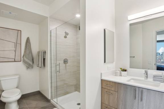 A bathroom with a toilet, sink, and shower.