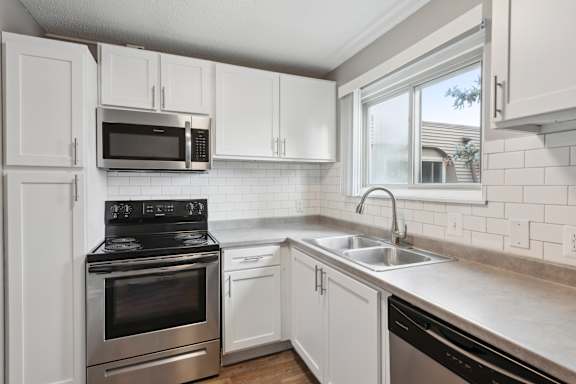 Kitchen with white cabinets and stainless steel appliances at Cedarvale Highlands Apartments, Eagan, 55122