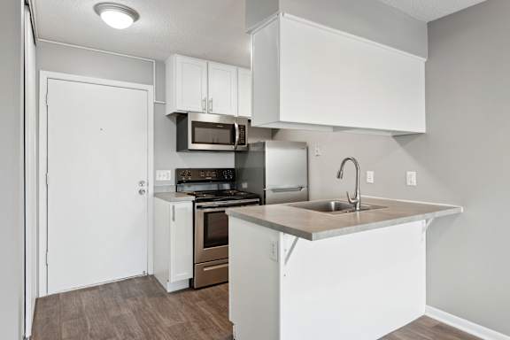 White kitchen with island and stainless appliances at Cedarvale Highlands Apartments, Eagan, MN 55122