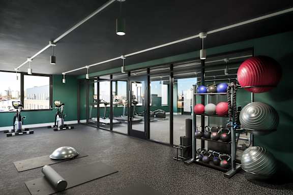 A gym with a variety of exercise equipment including weights and exercise balls.