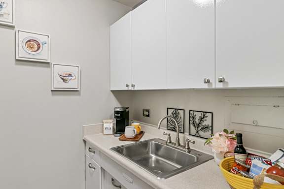 A kitchen with a sink and a yellow basket on the counter.