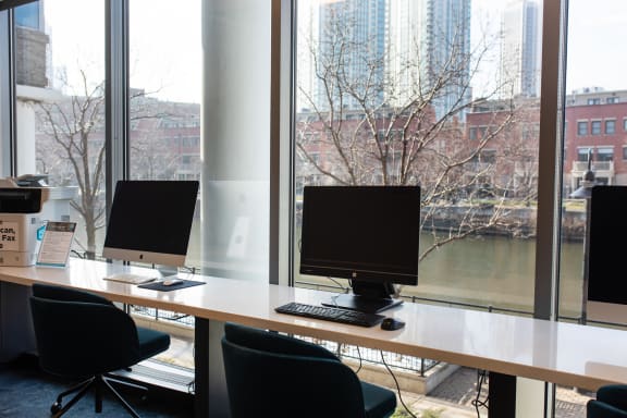 a desk with three computer monitors on top of it at Kingsbury Plaza, Chicago, IL, 60654