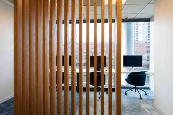 a view through the wood slats of an office space with a desk and computer monitor at Kingsbury Plaza, Illinois, 60654