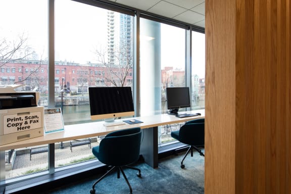 a desk with two computer monitors and two chairs in front of a window at Kingsbury Plaza, Chicago, IL, 60654