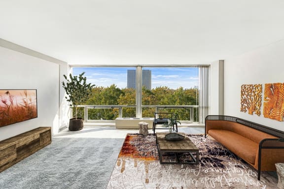 a living room with a large window and a view of the city at The Pavilion, Detroit, MI