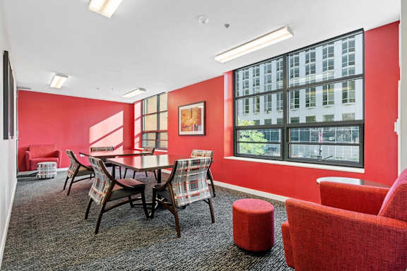 A room with red walls and a table with chairs.