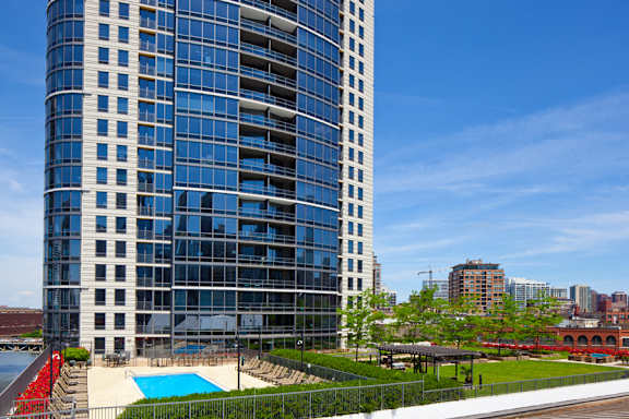 A tall building with a pool in front of it.